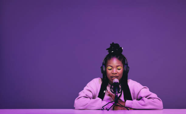 Female podcaster whispering into a microphone in a recording studio