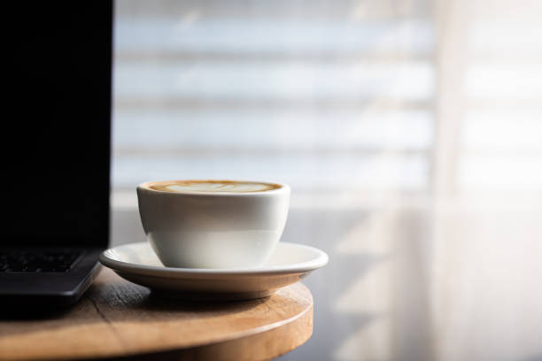 istock Start your working day with hot latte coffee cup background, laptop and mobile phone at work. 1494521546