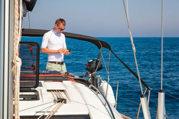 istock Businessman with smart phone on sailboat 1494524477