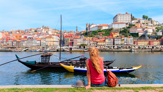 Traveler woman tourist enjoying traditional boat on douro river and Porto city- Portugal
