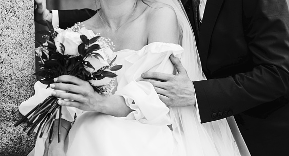 wedding couple embracing after wedding ceremony in city. Elegant bride and groom with wedding bouquet