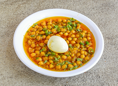 anda channay or boiled egg chickpeas served in plate isolated on grey background top view of pakistani and indian spices food
