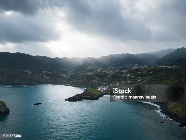 Madeiras Hilly Coastline Village On The Blue Ocean In A Cloudy Day Stock Photo - Download Image Now