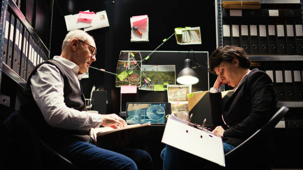 Agents examine surveillance footage Agents examine surveillance footage and classified documents, reading confidential police records to piece the puzzle. Team of private inspectors evaluate forensic evidence reports. Tripod shot. tripod attack stock pictures, royalty-free photos & images