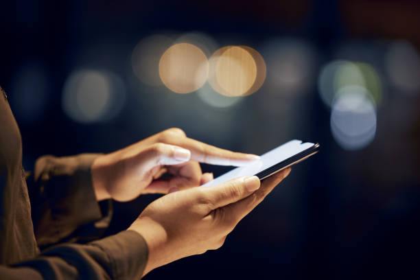 istock Closeup, hands and person with smartphone, night and typing with connection, communication and chatting. Zoom, woman and female with cellphone, light and search internet for information and website 1494532845