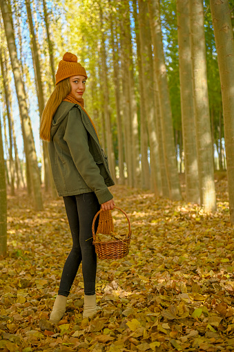 Young girl walking through a poplar tree in autumn