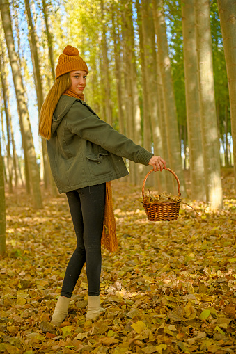 Young girl walking through a poplar tree in autumn
