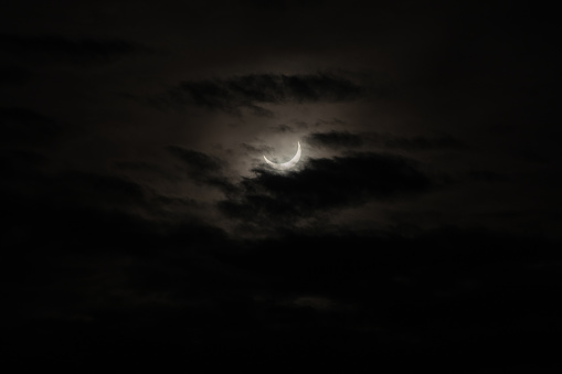 Distant crescent moon, beneath a sheet of clouds covering the night sky - POA,  SAO PAULO,  BRAZIL.