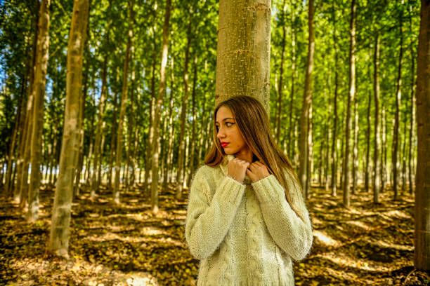 Young girl walking through a poplar tree in autumn