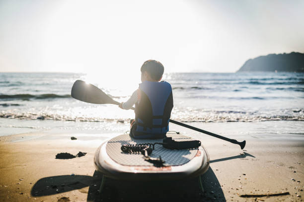 istock Boy preparing for Stand Up Paddle-boarding in the beach 1494534000