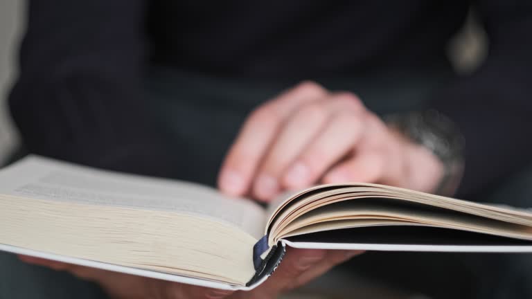 Young Man Reading a Book and Turning Pages, Close Up, Slow Motion