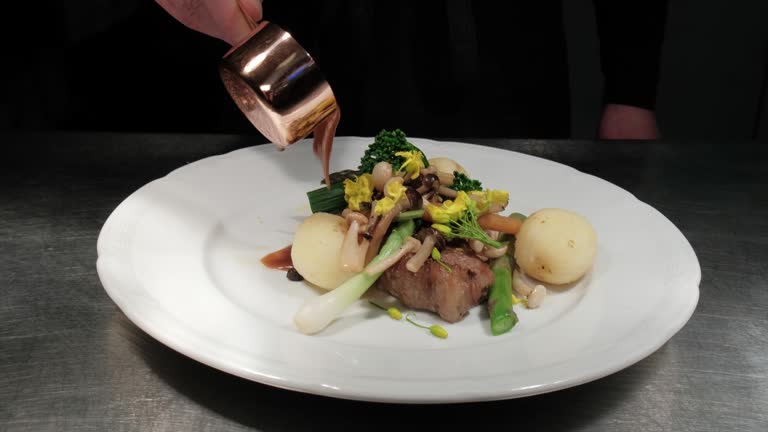 Chef Pouring a Port Infused Sauce Over a Steak