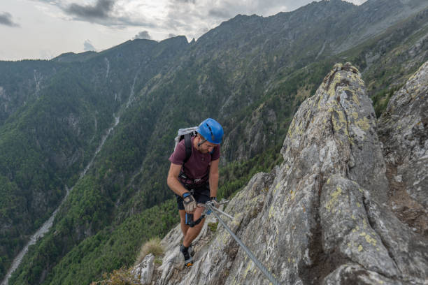 istock Man on alpine route climbs over ridge 1494536928