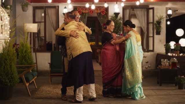 Authentic Shot of Indian Elderly Couple Receiving Family Relatives Over. Genuine Happiness in a Reunion Between Friends to Celebrate Diwali Together. Greetings, Appreciation and Gifts are Shared