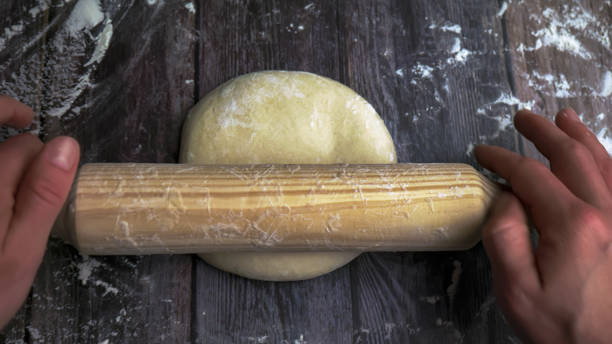 istock Rolling pin dough to make the pizza base a first-person view. 1494539051