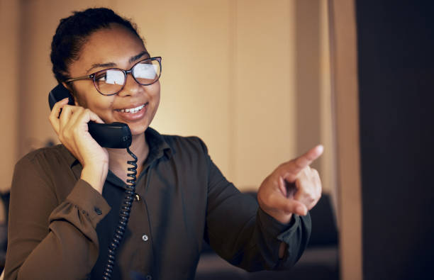 telephone, night and business woman on desktop monitor for technical support, global information or online career. professional black person on computer, phone call discussion and work from home help - financial occupation research data glasses imagens e fotografias de stock