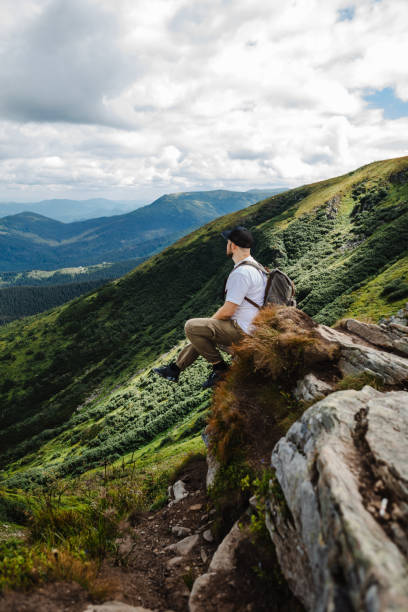 istock Man on top of a mountain sitting on a rock 1494540790