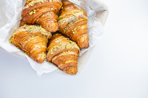 Croissants in Wicker Basket on white table