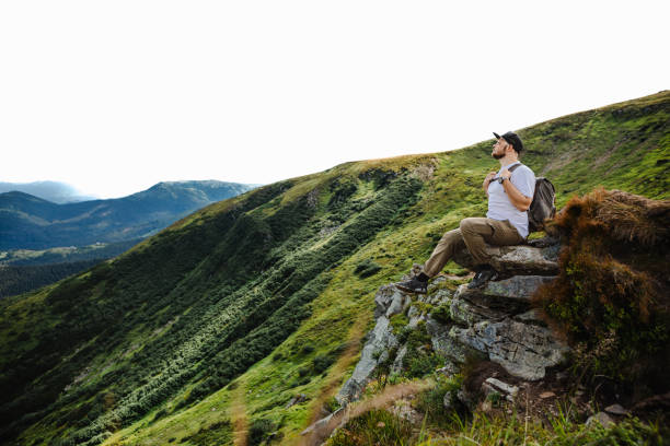istock Man on top of a mountain sitting on a rock 1494540833