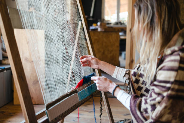 istock Crafty woman weaving at a loom at her workshop 1494542342