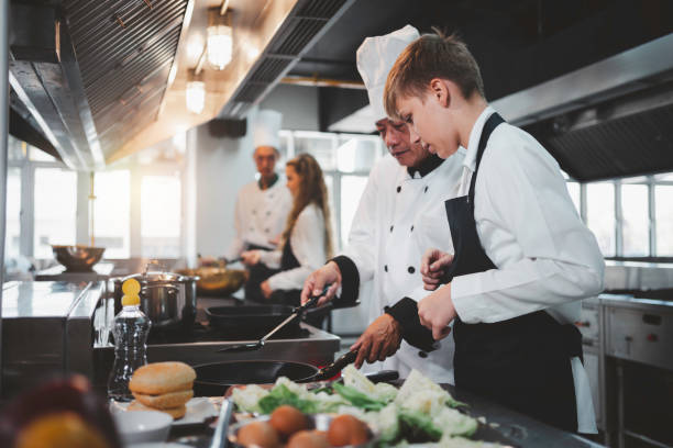 istock Chef teaching students to cook in the kitchen at a cooking school 1494544304