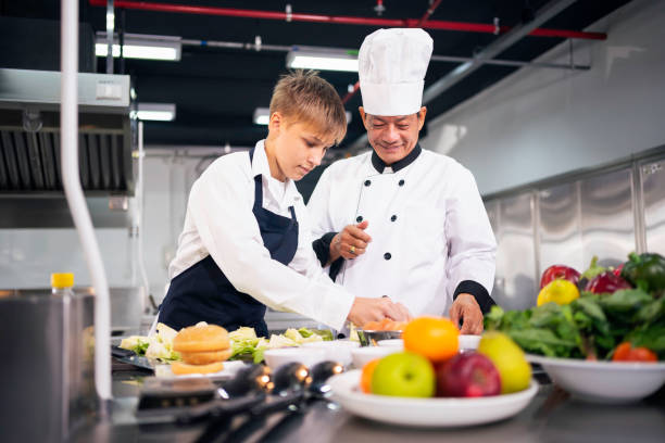 istock Chef teaching students to cook in the kitchen at a cooking school 1494544308