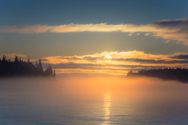 Sun rising over Penobscot Bay with islands and mist, Birch Point State Park, Maine