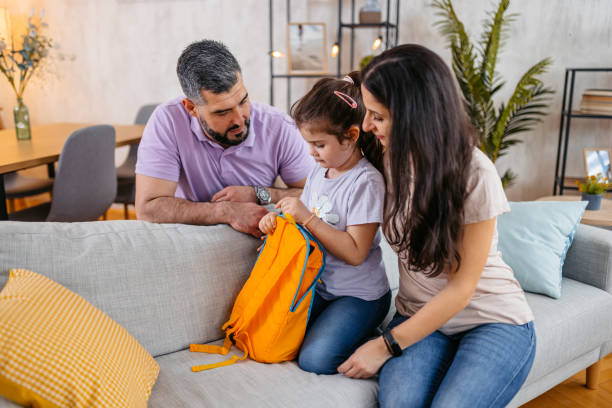 istock Daughter Packing Her Backpack For School With The Help Of Her Parents 1494545280