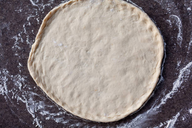 istock Rolled out pizza dough on floured slate surface, photographed overhead 1494545442