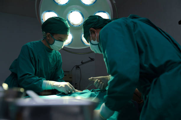 istock Closeup image of professional concentrated surgical team hands performing an operation with patient in hospital operating room. Surgery concept. 1494546092