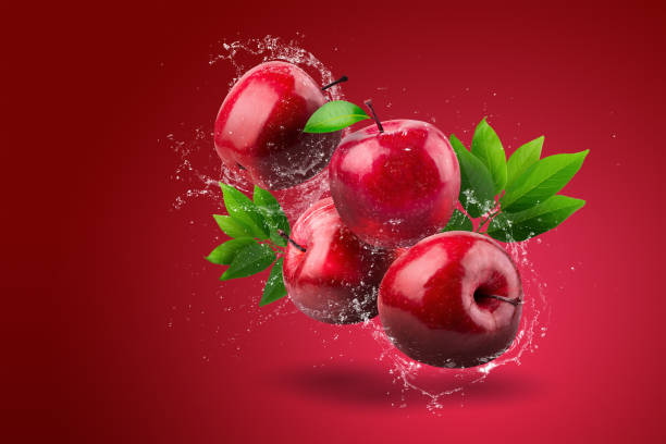 istock Water splashing on Fresh Red apple on red background 1494547376