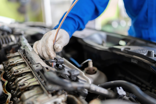 An annual engine check can help prevent engine damage. Close up mechanical engineer hand insert the plastic tube into engine crankcase to collect engine oil for used oil analysis to prevent engine breakdown.