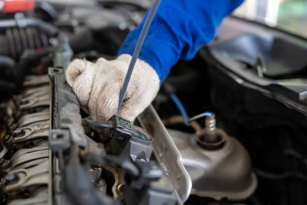 istock Check engine to increase engine efficiency. Professional car leader wearing mechanic uniform suit inspector the car engine and unscrew the nut to open the engine cover in the garage car repair shop to improve power efficiency. 1494549590