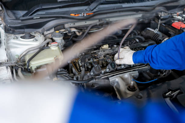 istock Check engine to increase engine efficiency. Professional car leader wearing mechanic uniform suit inspector the car engine and unscrew the nut to open the engine cover in the garage car repair shop to improve power efficiency. 1494550147