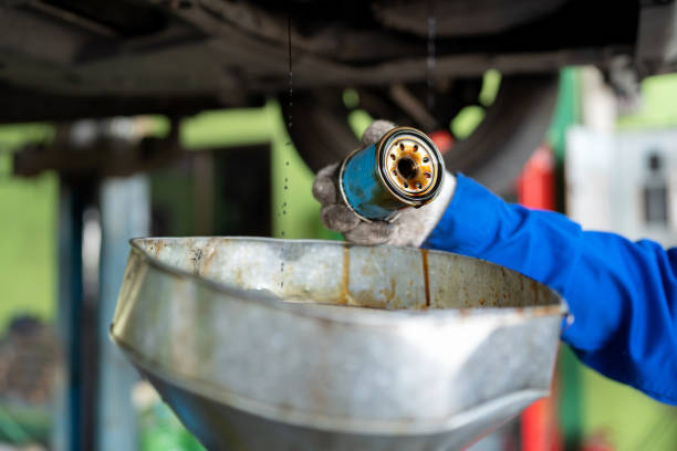 An oil change helps keep your engine looking like new. Drain used engine oil from engine crankcase in the waste drum after drive over 10,000 kilometers and looking at the oil filter to check the particle block in the repair shop at garage.