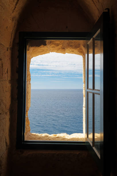 Looking at the Mediterranean sea through an old window of a defense tower stock photo