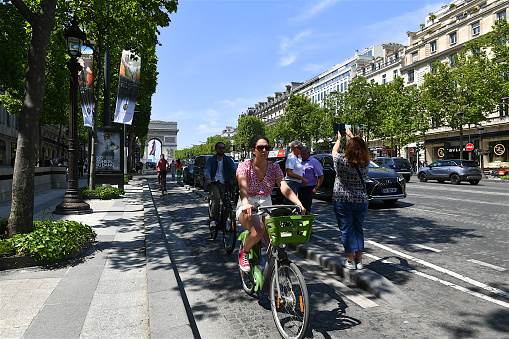 Paris, France-05 27 2023: Group of cyclists going down the avenue des Champs-Elysées in Paris, France.