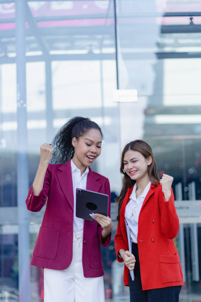 istock Two young women looking excited about their work holding a digital tablet smiling happily with their work. 1494561870