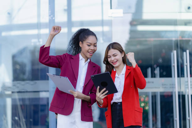 istock Two young women looking excited about their work holding a digital tablet smiling happily with their work. 1494561905