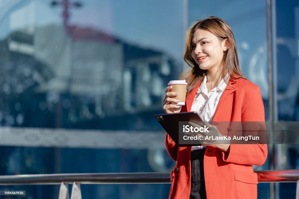 Glad kvinne som holder nettbrettet utendørs Afroamerikansk kvinne ved hjelp av digital enhet ser på kameraet smilende og jobber utendørs Adult Stock Photo