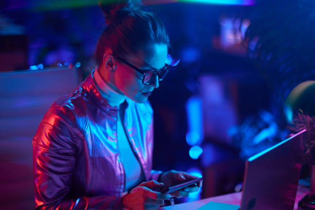 istock elegant female in glasses with laptop using smartphone 1494564404