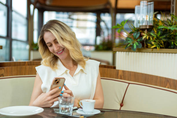 istock Woman looking at her smartphone coffee break in cafe 1494564498