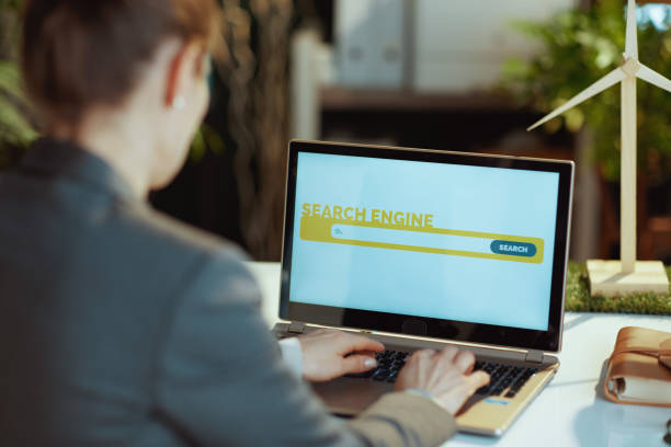 istock Seen from behind modern woman with laptop using search engine 1494568696