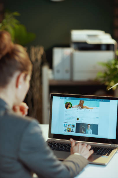 Seen from behind modern woman working on social media account