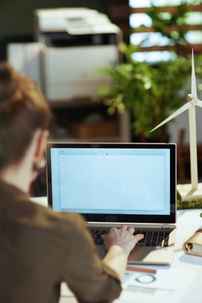 istock Seen from behind modern female with laptop writing email 1494568723