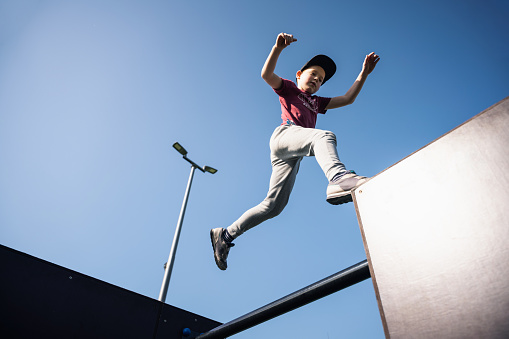 Happy 4 year old boy jumping in the air. Happiness concept.