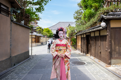 Portrait of Japanese Maiko (Geisha in training) standing on street in Gion, Kyoto