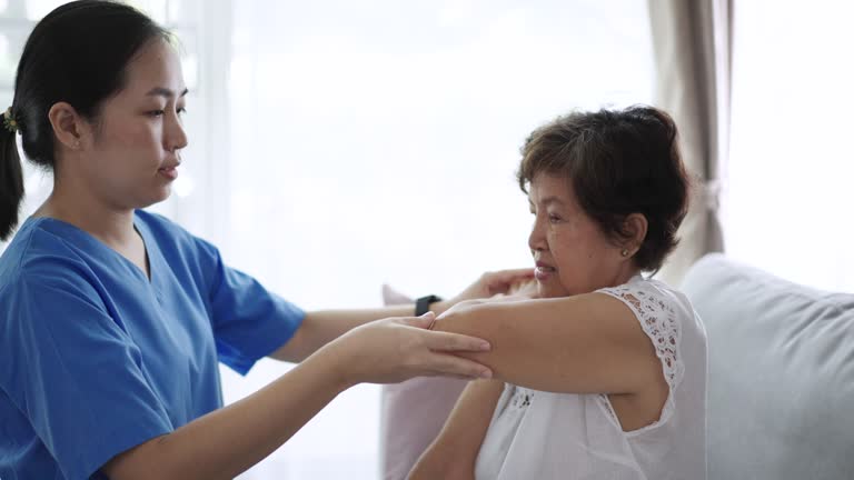 Physiotherapist teaching elderly women stretching at home