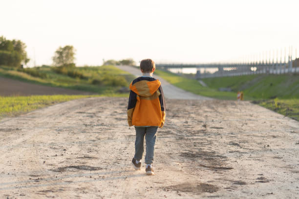 istock Young Boy Walking near the Forest 1494571071