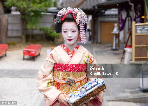 京都の祇園の通りを歩く日本の舞妓(訓練中の芸者)